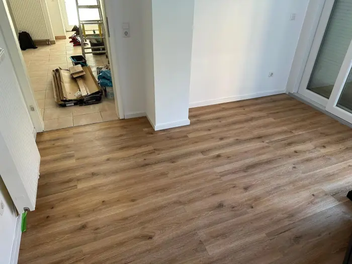 Neu verlegter Bodenbelag in Holzoptik im Flur einer renovierten Wohnung