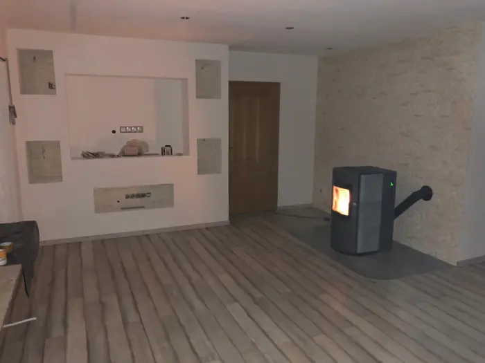 Fertig ausgebauter Wohnraum mit Holzboden, Pelletofen und Wandnische