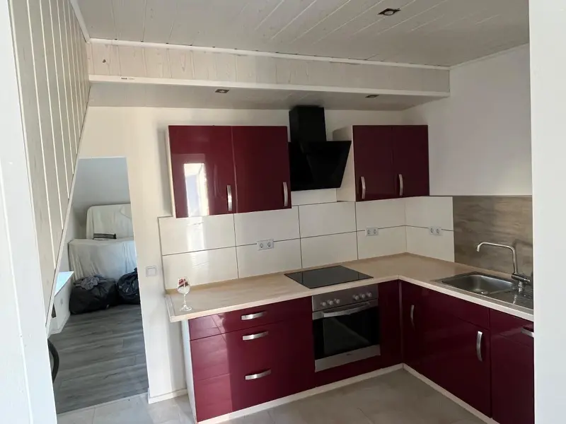 Neue Küchenzeile mit roten Fronten in renovierter Wohnung