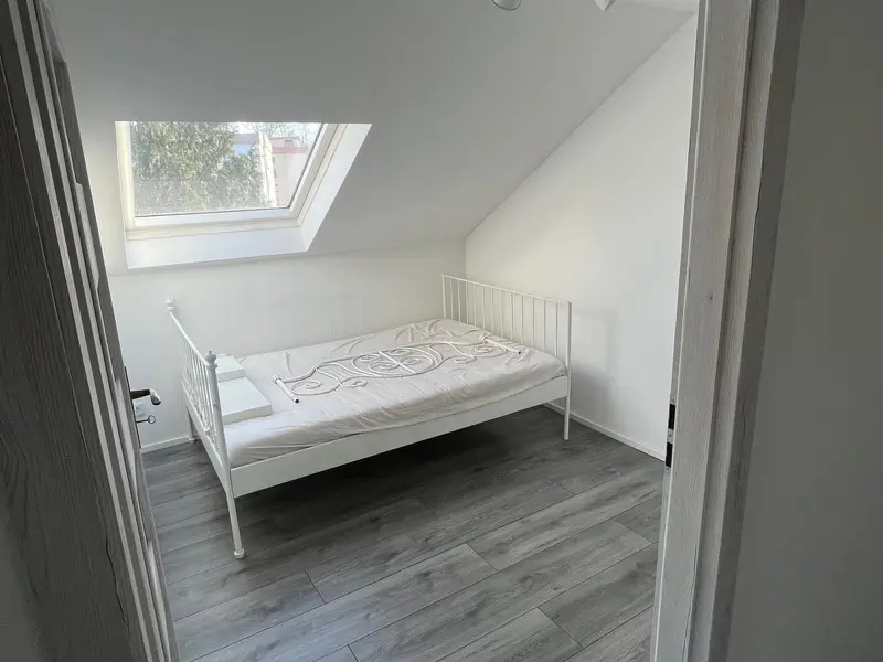 Fertiges Schlafzimmer im Dachgeschoss mit Dachfenster und neuem Boden